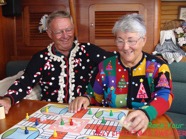 Couple plays Parcheesi in ugly Christmas sweaters