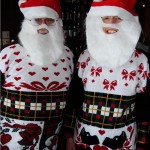 couple wearing matching ugly christmas sweaters and santa beards