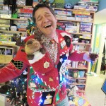 Photo: Man in ugly Christmas sweater makes a wine toast in front of Christmas tree.