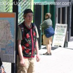 Picture of Brian Clark Howard waiting for the bus in an ugly Christmas sweater vest