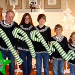 Picture of family in giant candy cane ugly Christmas sweaters