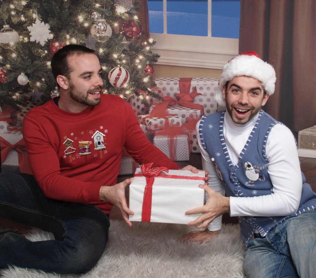 Twins fight over a present under tree in ugly Christmas sweaters