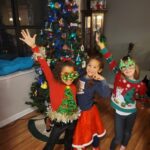 Kids pose in colorful ugly Christmas sweaters